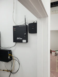 Technician installing access control panel on a secure office door.