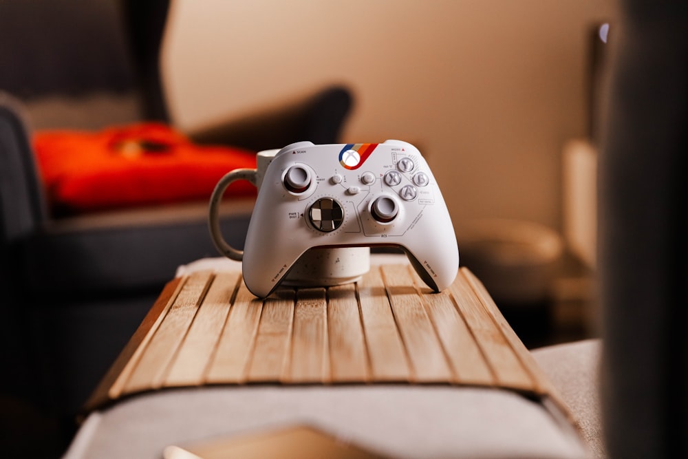 a video game controller sitting on top of a wooden table