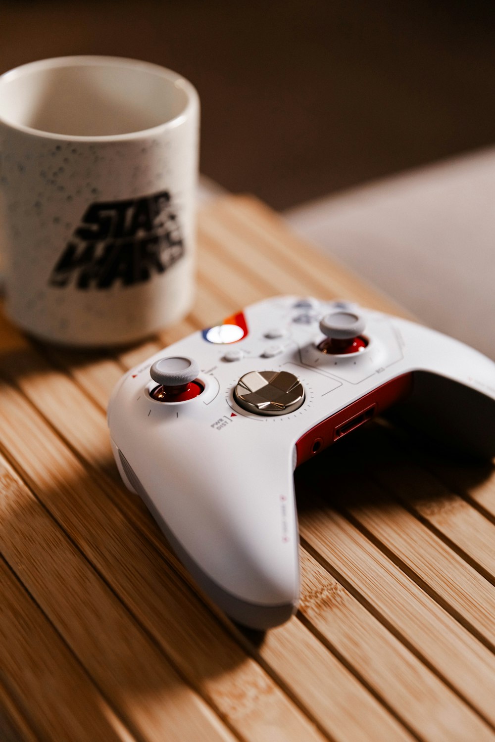 a video game controller next to a cup of coffee