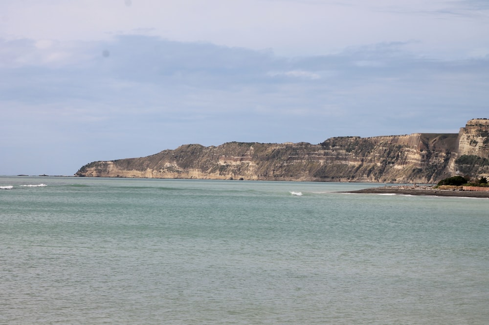 a large body of water with a mountain in the background