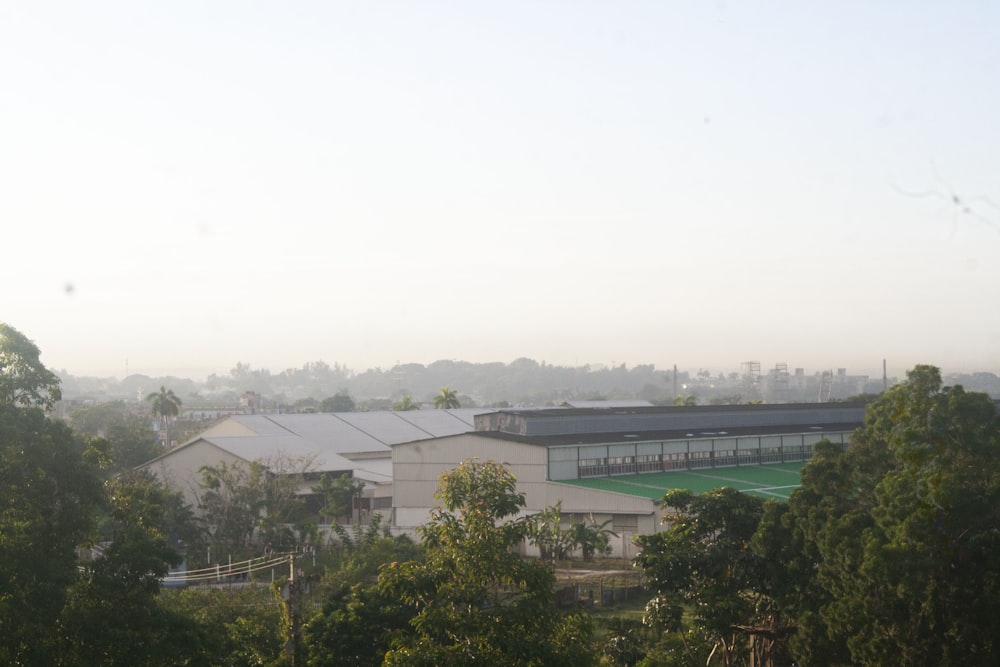 a large building surrounded by trees and a tennis court