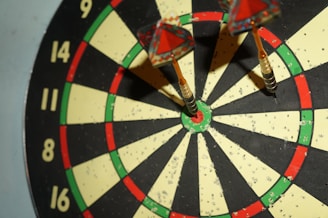 Close-up of a dart hitting the bullseye on a well-lit board.
