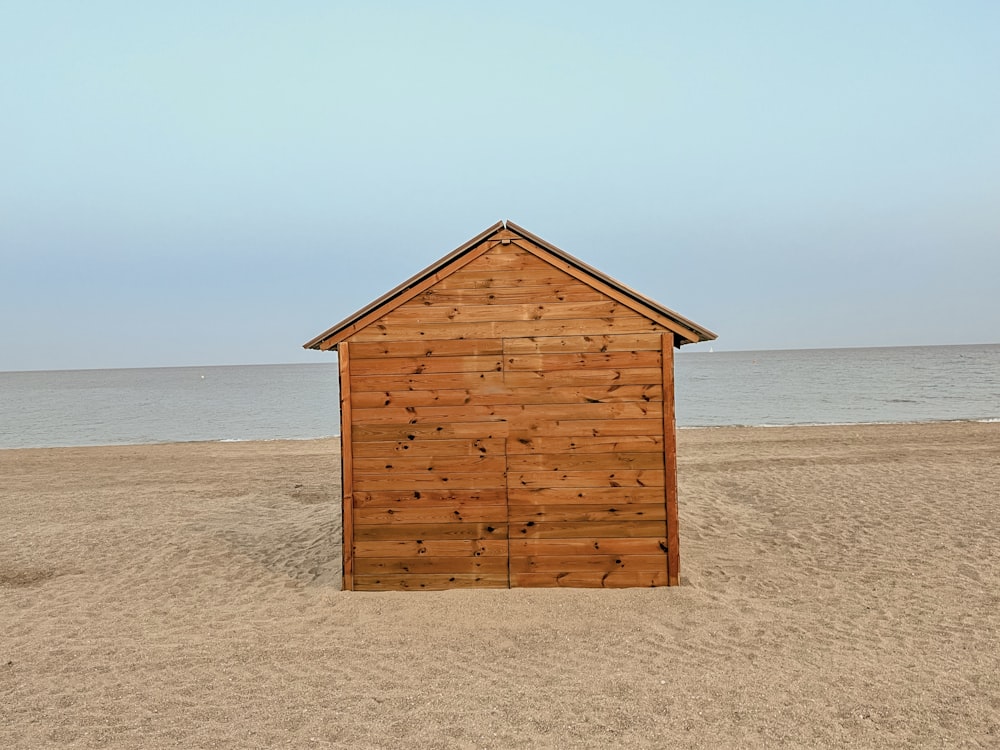 a small wooden building sitting on top of a sandy beach