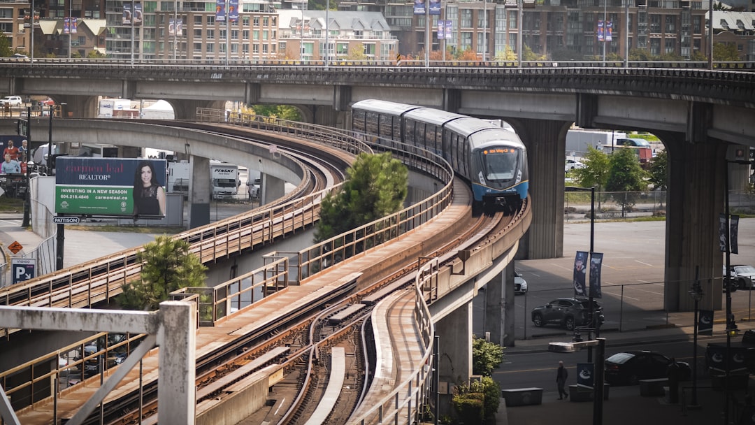 a train traveling down tracks under a bridge,