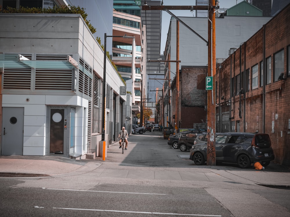 a man riding a bike down a street next to tall buildings