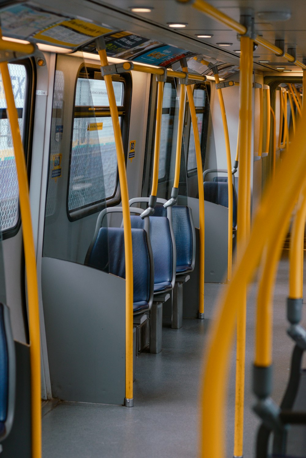 the inside of a subway car with blue and yellow seats