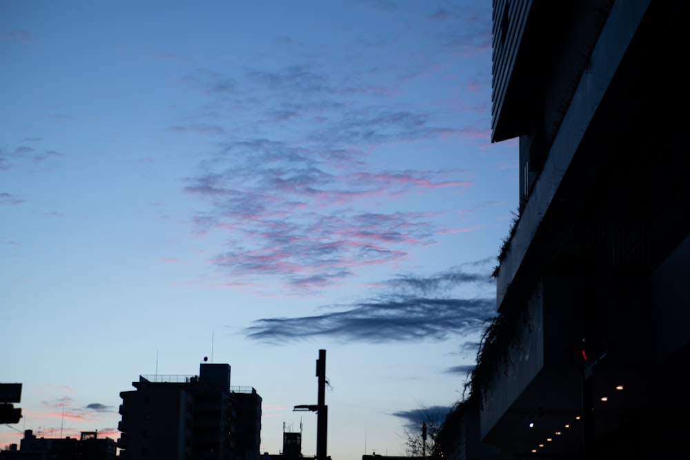 a city street at dusk with a few clouds in the sky