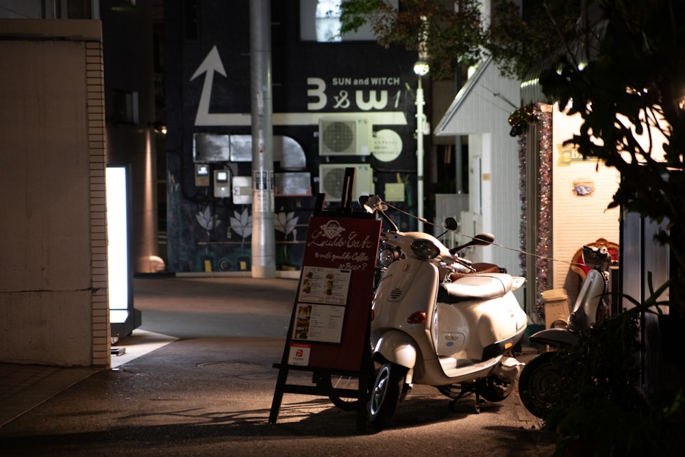 a scooter parked on the side of a street at night