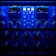 A close-up view of an audio processing panel, featuring various knobs, dials, and buttons. The panel displays intricate details such as compression meters, EQ controls, and frequency adjustments. The lighting casts a deep blue hue over the entire panel, giving it a high-tech, sophisticated appearance.
