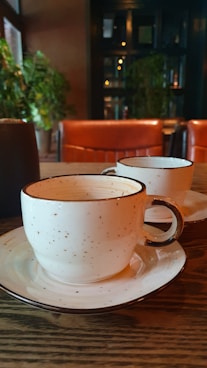 a couple of cups sitting on top of a wooden table
