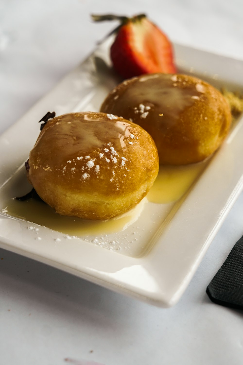 quelques beignets assis sur une assiette blanche