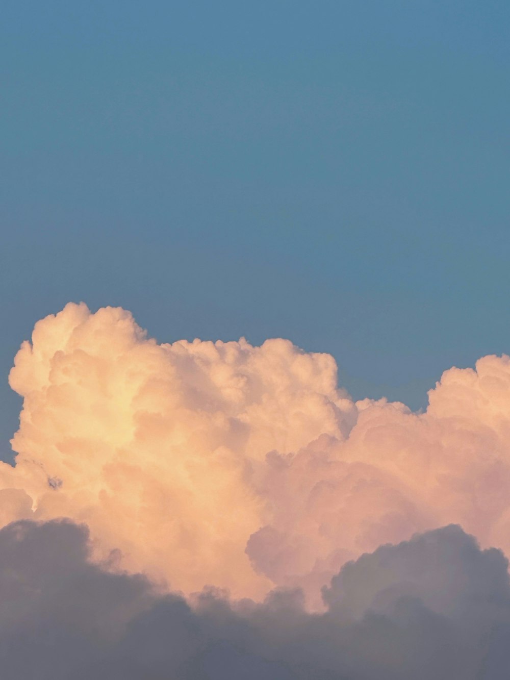 a plane flying through a cloud filled sky