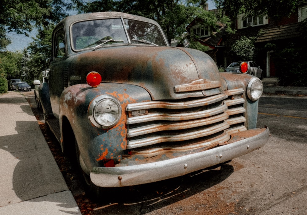 an old rusty truck parked on the side of the road