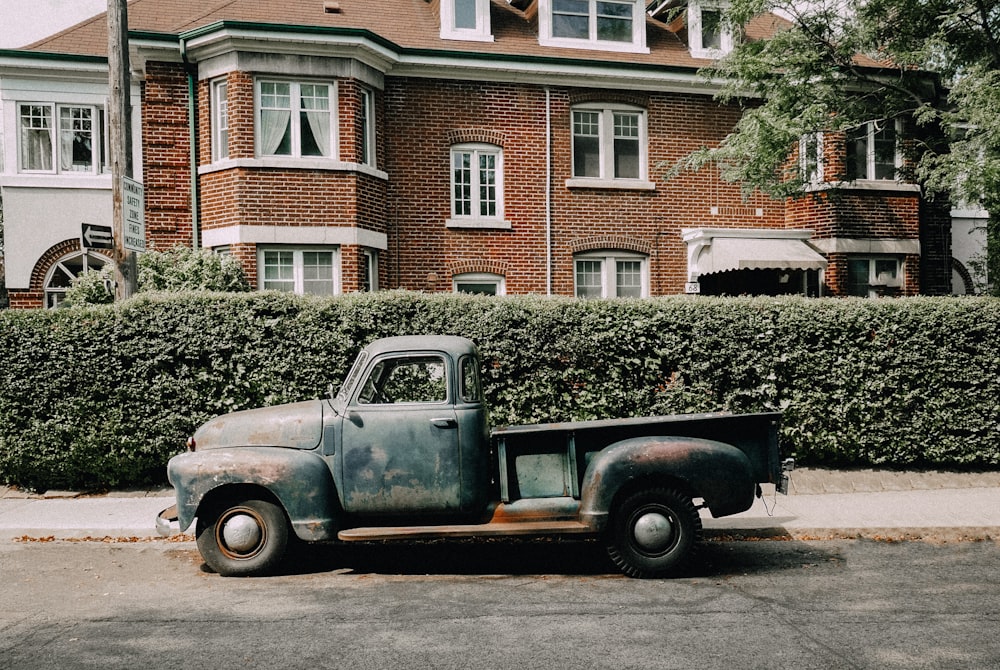 an old truck is parked in front of a house