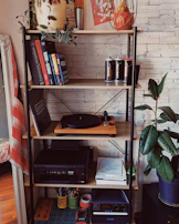 A stylish shelf showcasing a mix of electronic gadgets and tasteful home decor accents.