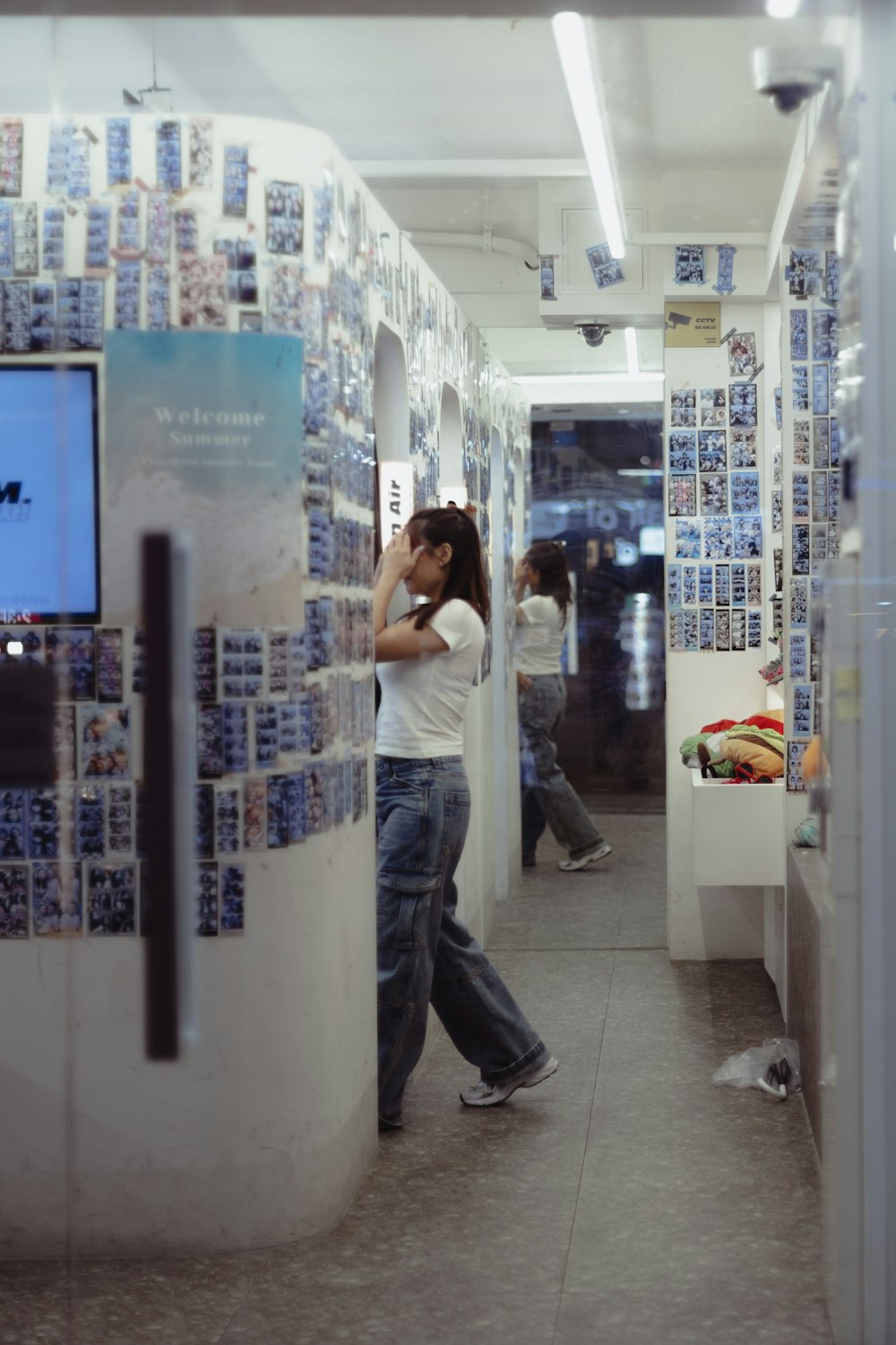 a man walking down a hallway next to a tv