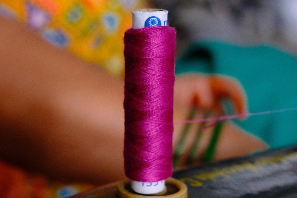 a spool of thread sitting on top of a sewing machine