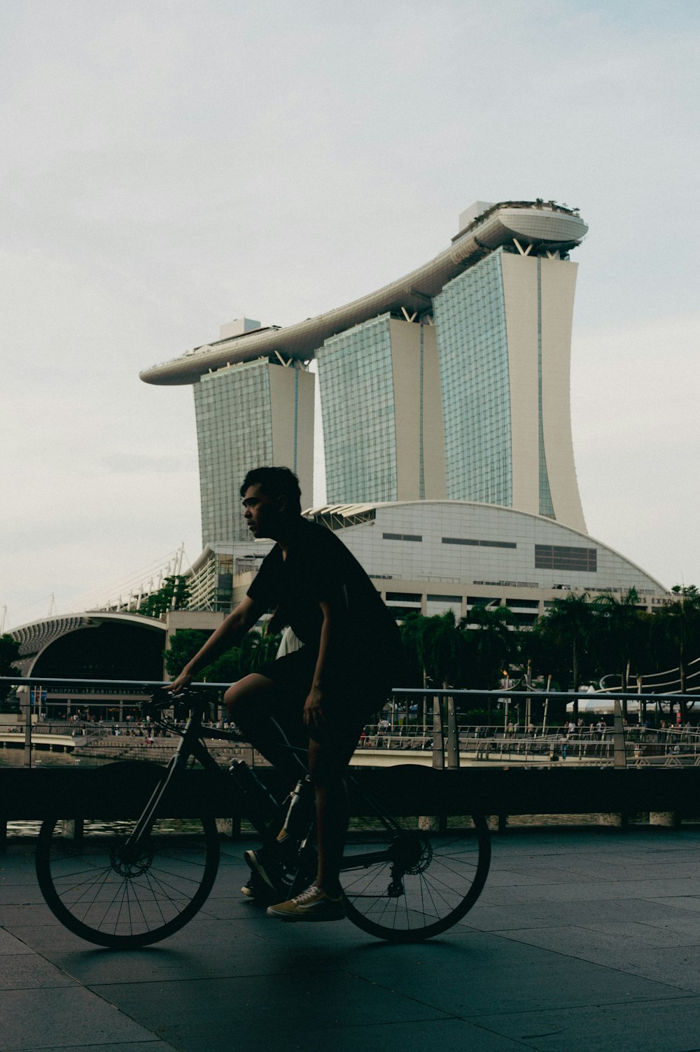 a man riding a bike down a street next to tall buildings