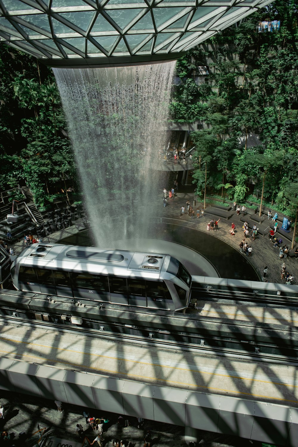 a train on a track near a waterfall