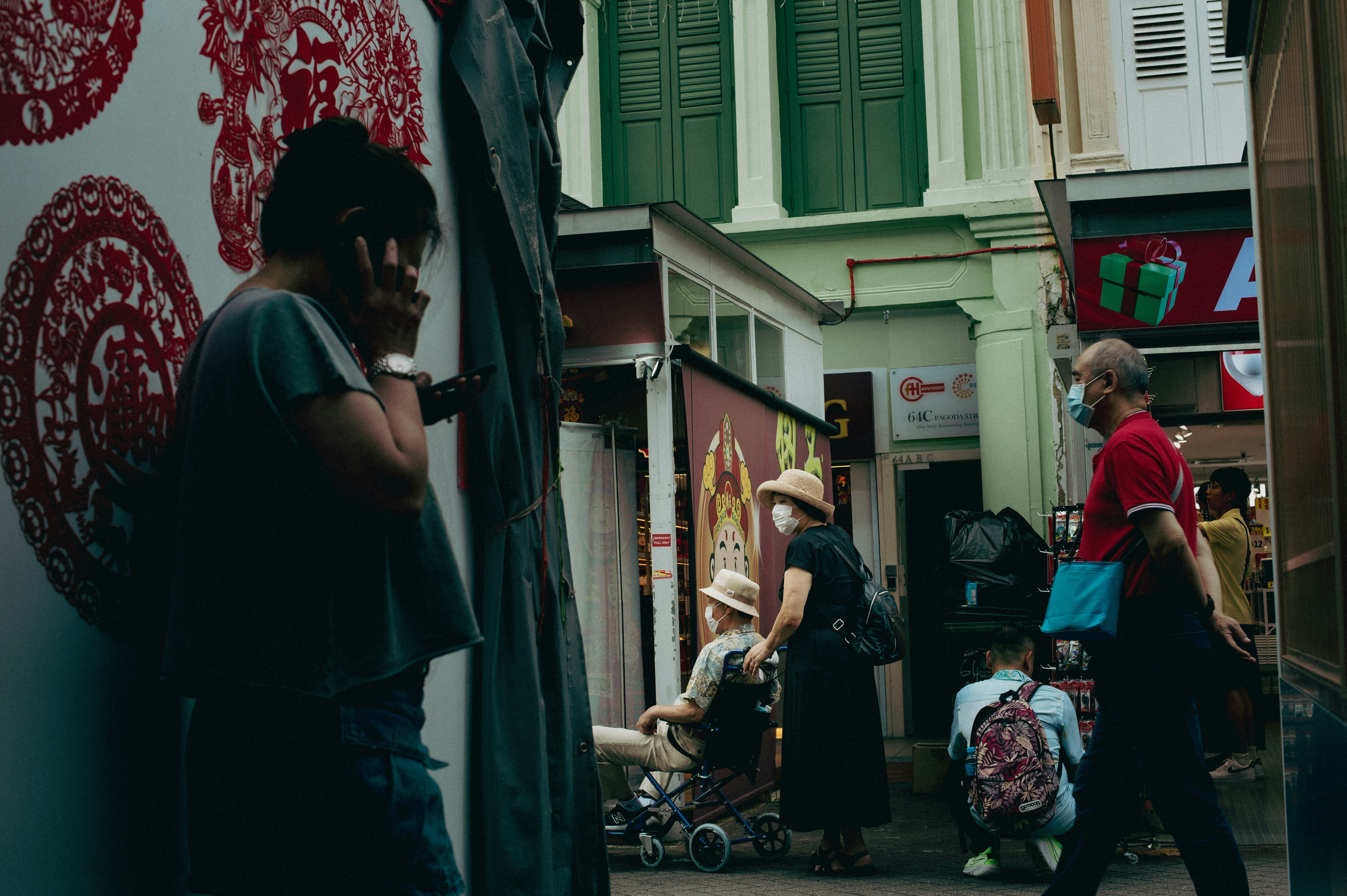 a group of people walking down a street next to tall buildings