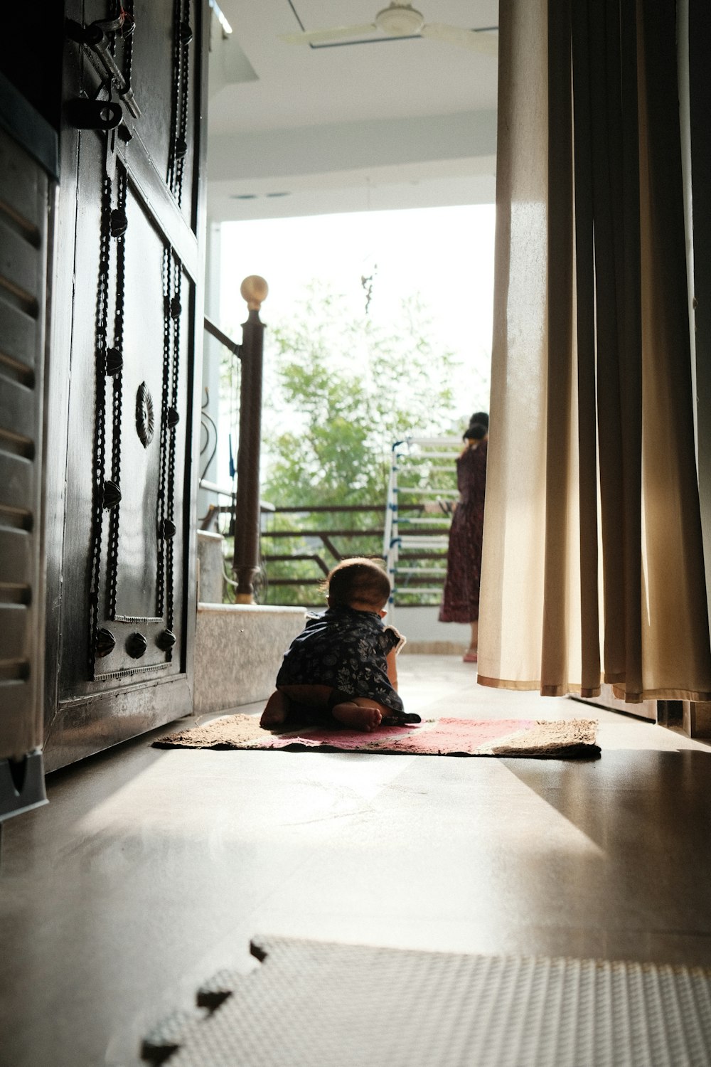 a child sitting on the floor in front of a door
