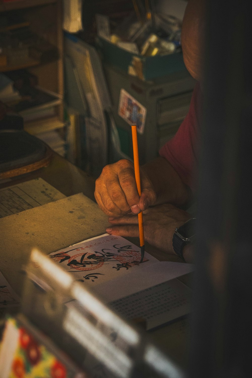a person sitting at a desk with a pencil in their hand