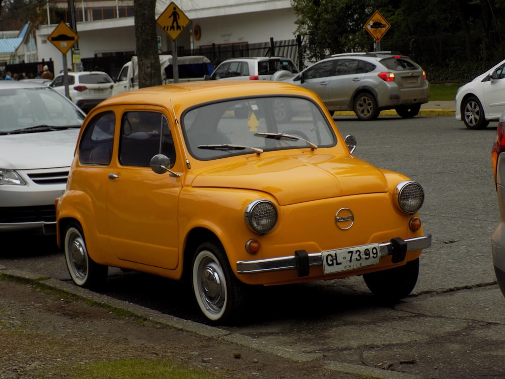 a small yellow car parked on the side of the road
