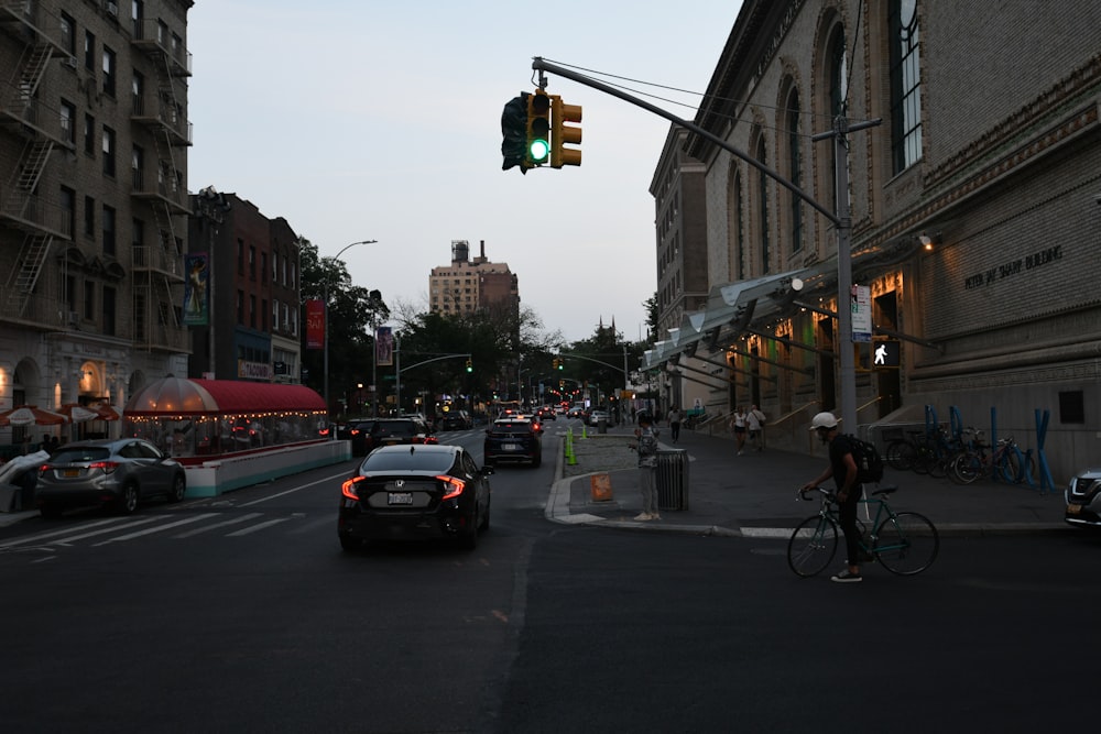 a man riding a bike down a street next to a traffic light