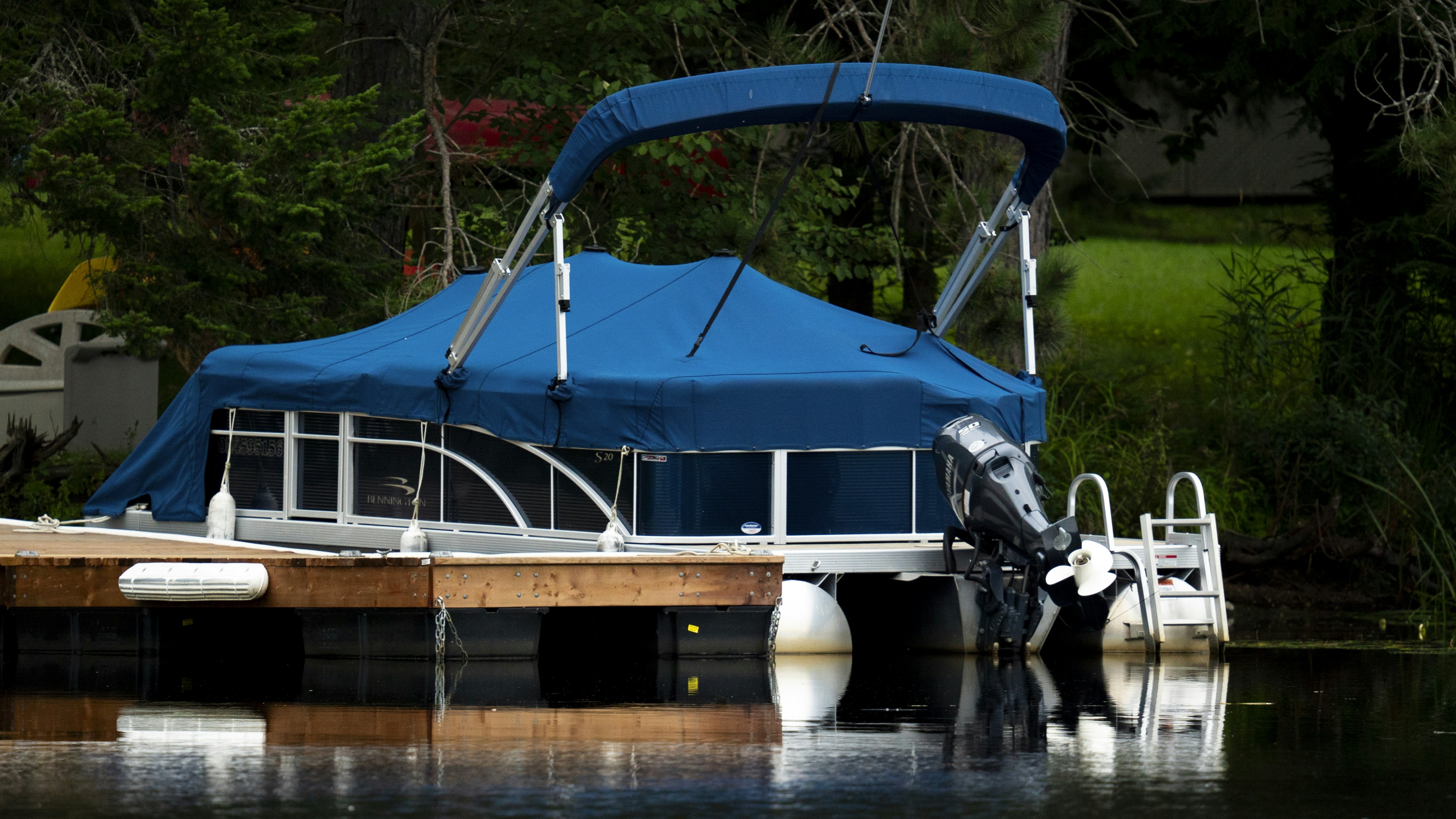 A boat docked at a dock with a blue tarp over it photo Free
