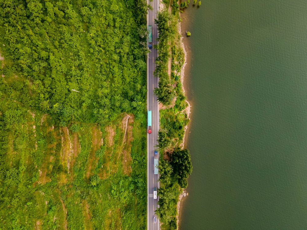 an aerial view of a road next to a body of water