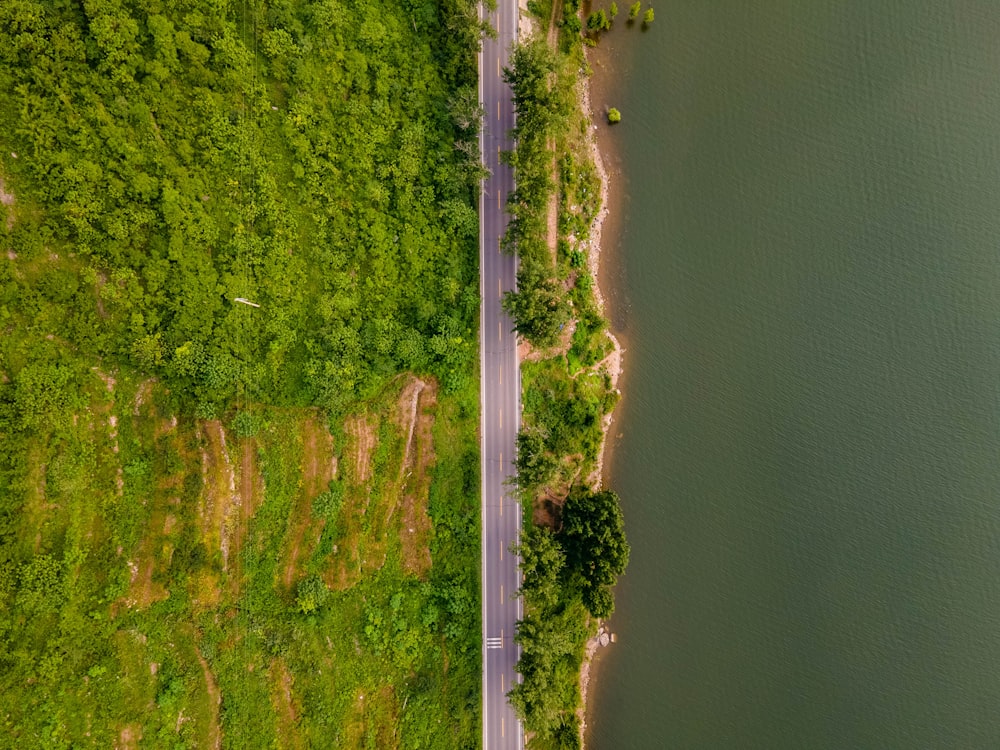 an aerial view of a road next to a body of water