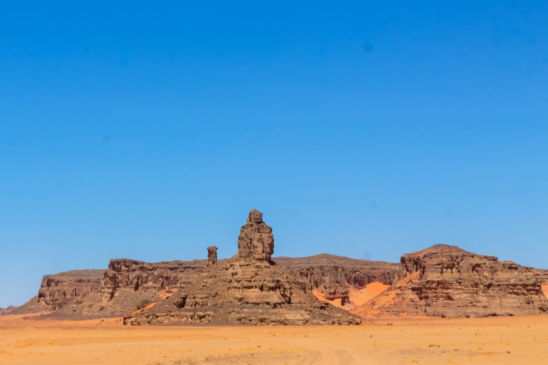 a large rock formation in the middle of a desert