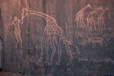 A group of safari travelers observing ancient rock paintings in Uganda.