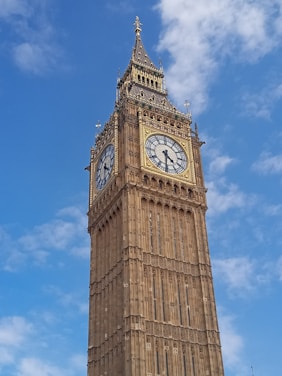 A skilled technician carefully restoring a vintage tower clock against a bright blue sky.