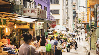 A vibrant street scene from a bustling international market filled with colorful stalls.