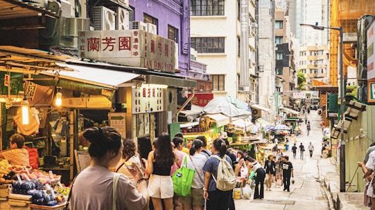 A vibrant photo shoot capturing a bustling Asian market street filled with colorful stalls and smiling tourists.