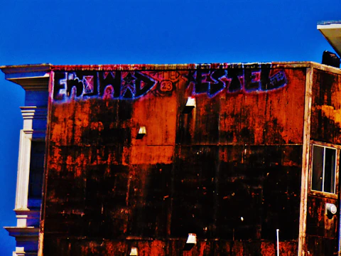 A vibrant storefront wall freshly cleaned from graffiti under a clear sky.