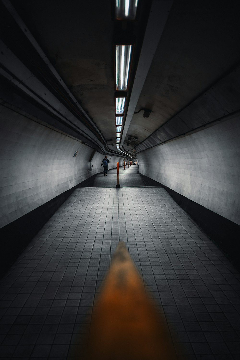 a person walking down a long hallway in a building