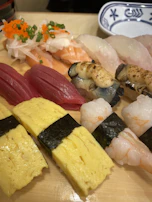 Artfully arranged nigiri pieces with glistening slices of fish on rice.
