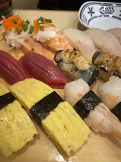 Artfully arranged nigiri pieces with glistening slices of fish on rice.