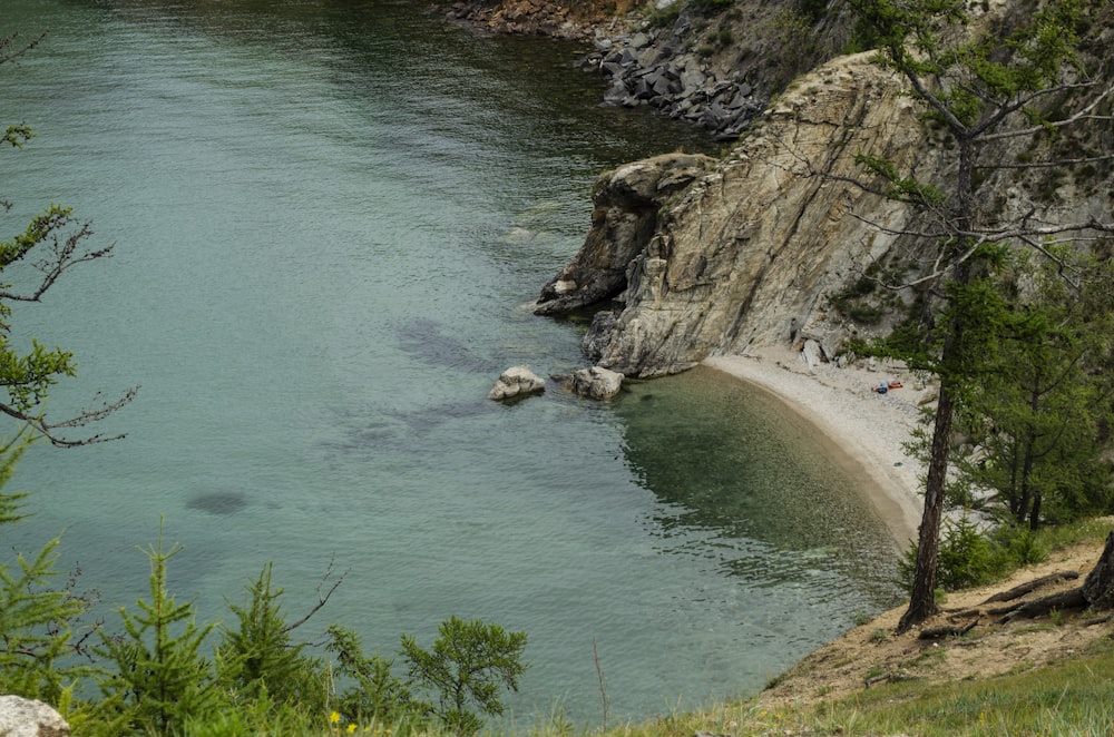 uno specchio d'acqua circondato da alberi e rocce