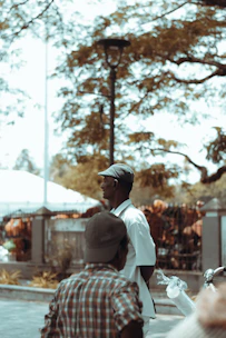 Two men having a thoughtful conversation outdoors in a park.