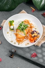 A beautifully plated dish of golden ginger chicken garnished with fresh herbs and a side of steamed rice.