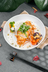 A vibrant plate showcasing golden fried ginger chicken garnished with fresh herbs.