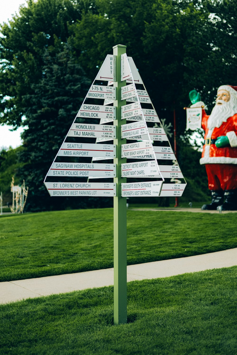 a street sign with a santa clause in the background