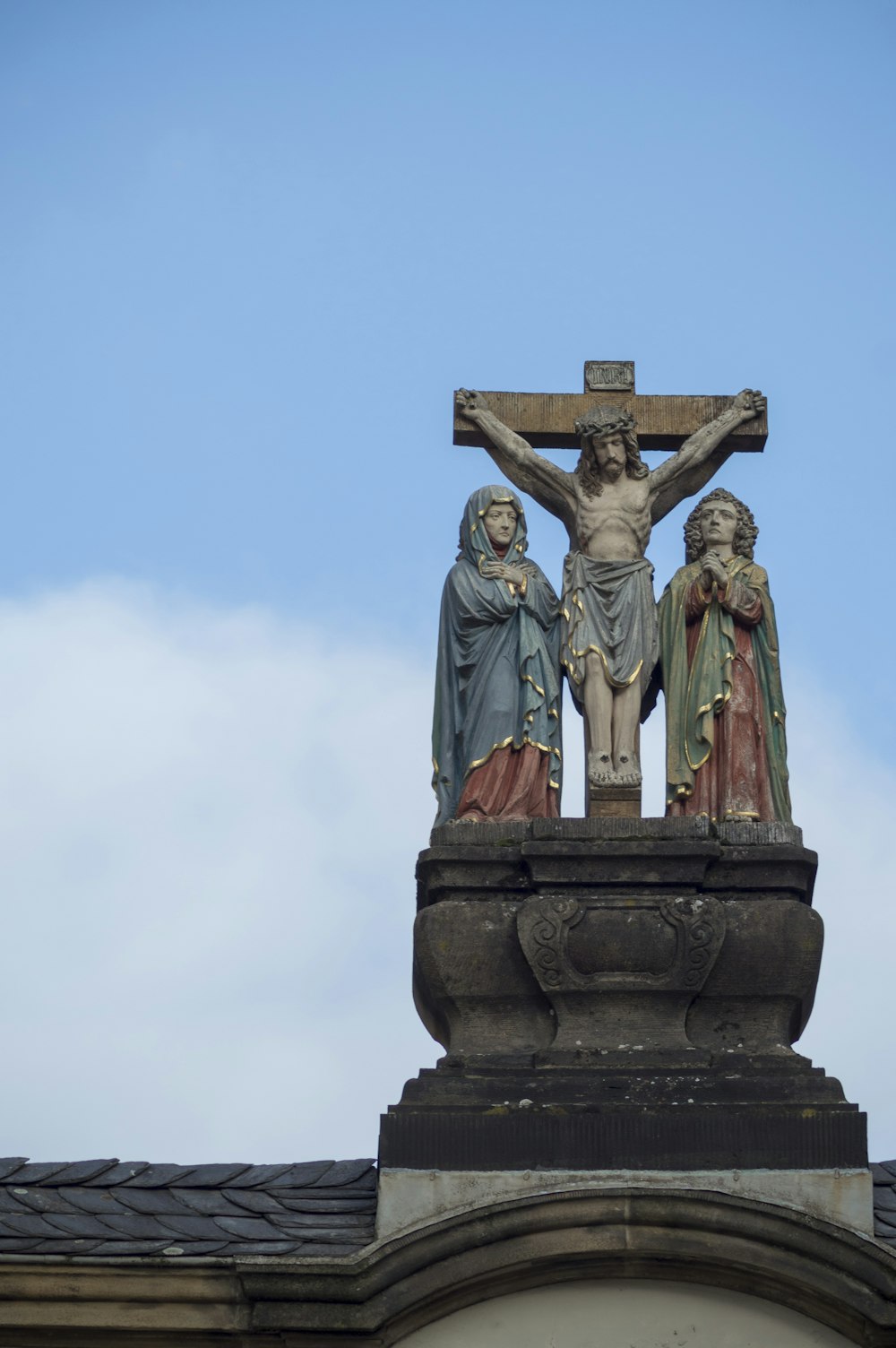 a statue of jesus on the cross on top of a building