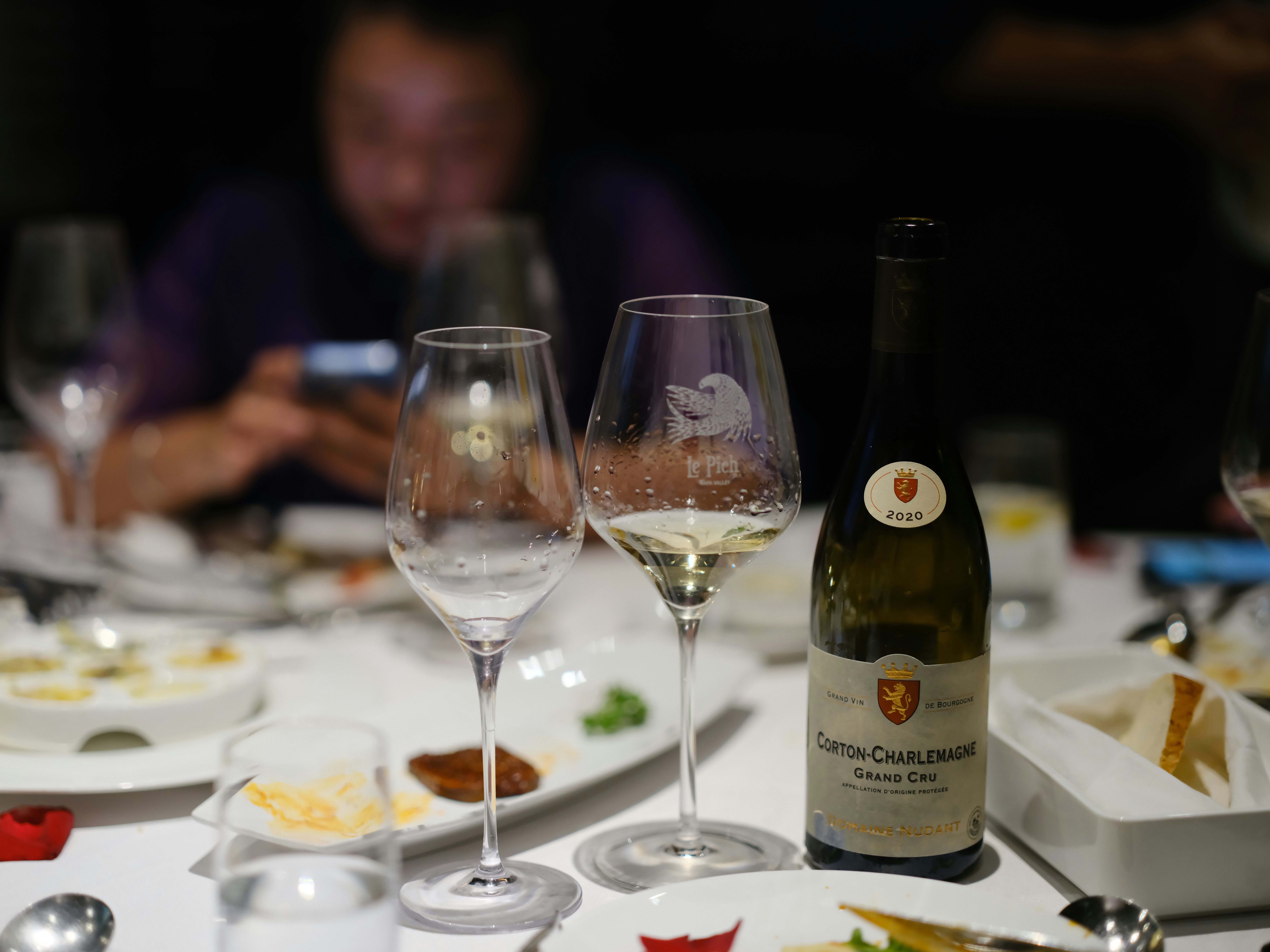 une table surmontée d’assiettes de nourriture et de verres de vin