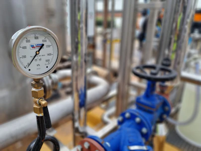 Close-up of hydraulic system pipes and valves with pressure gauges.