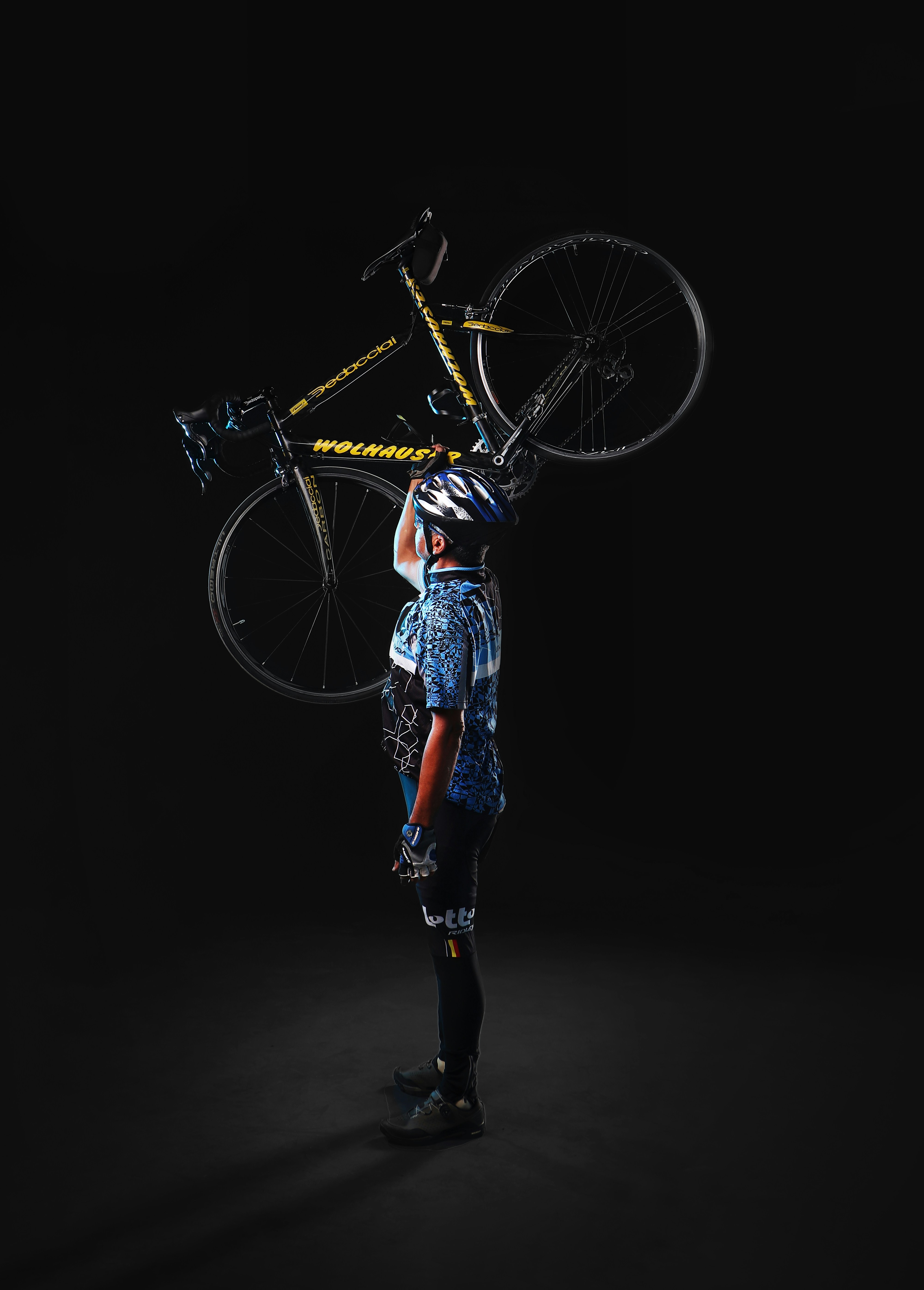 a man holding a bike on his shoulders