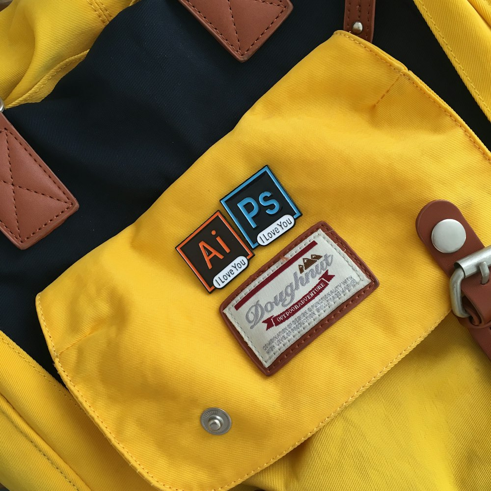 a close up of a yellow backpack with a sticker on it